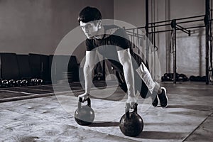 Handsome Strong man workout at gym, strength pushup exercise with Kettlebell.