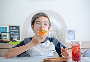 A handsome student schoolboy 8-9 years old wearing black glasses having snack