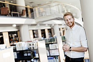 Handsome student smiling in library