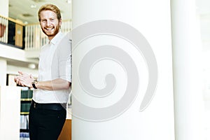 Handsome student smiling in library