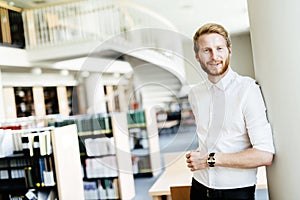 Handsome student smiling in library