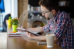 Handsome student studying in restaurant