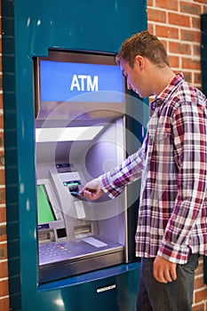 Handsome student withdrawing cash