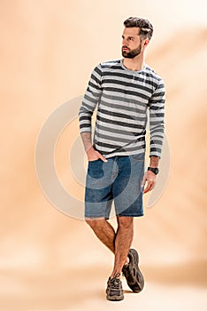 Handsome stylish bearded man posing in striped sweatshirt