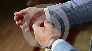 Handsome stylish man dressed in modern formal clothes buttoning jacket. Close up of hands of guy in blue jacket, white