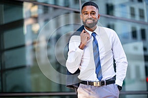 Handsome stylish trendy suit, african american businessman portrait downtown in city building, smiling with success and success