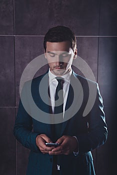 Handsome stylish young man writing sms on phone