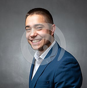 Handsome successfull businessman in blue suit sitting and showing expressions