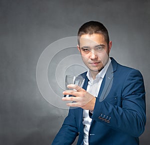 Handsome successfull businessman in blue suit sitting and showing expressions