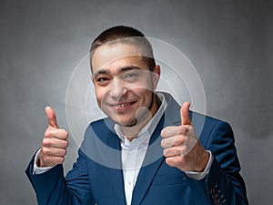 Handsome successfull businessman in blue suit sitting and showing expressions