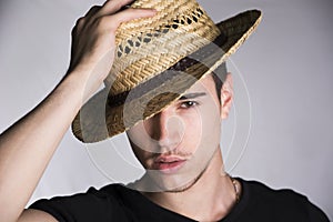 Handsome sultry young man with straw hat