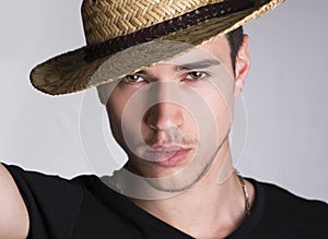 Handsome sultry young man with straw hat