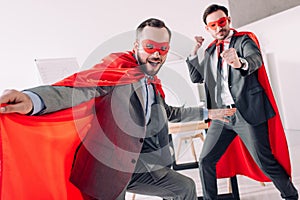 handsome super businessmen in masks and capes having fun