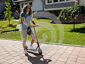 Handsome tall young man trying out his new electric kick scooter