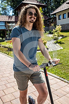 Handsome tall young man trying out his new electric kick scooter