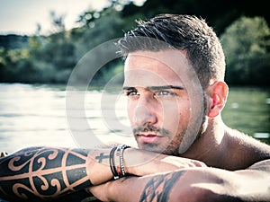 Handsome tattooed young man in boat