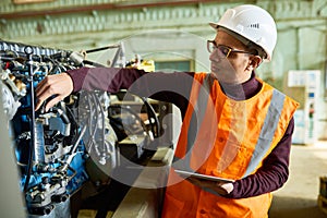 Handsome Technician Adjusting Engine Features