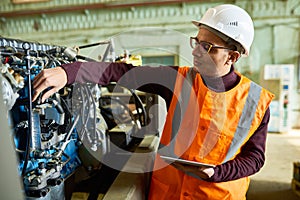 Handsome Technician Adjusting Engine Features photo