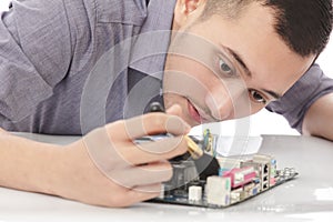 Handsome technician cleaning up the hardware of computer using b