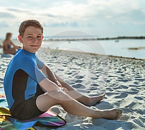 Handsome teen boy in neoprene swimsuit in Baltic sea