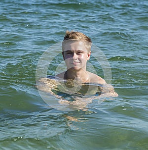 Handsome teen has fun swimming in the ocean