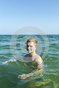 Handsome teen has fun swimming in the ocean