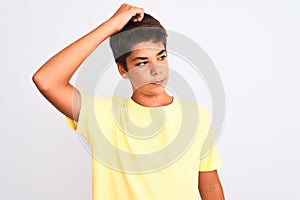 Handsome teenager boy standing over white isolated background confuse and wonder about question