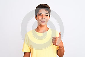 Handsome teenager boy standing over white isolated background doing happy thumbs up gesture with hand