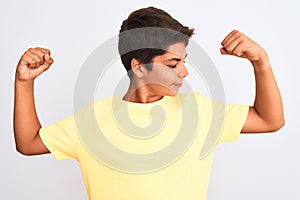 Handsome teenager boy standing over white isolated background showing arms muscles smiling proud