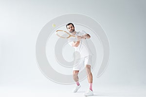 handsome tennis player hitting ball with tennis racket