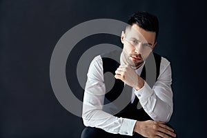 Handsome thoughtful man portrait in suit on dark background