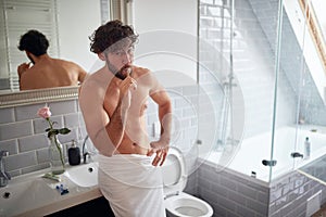 Handsome topless man brushing teeth
