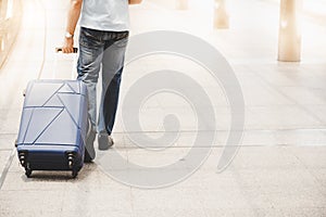 Handsome traveler guy drag suitcase to street at metropolis or c
