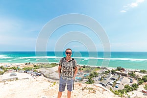 Handsome traveler man stay by blue ocean background - Happy guy relaxing at sea view point - Concept of freedom and