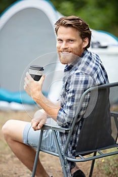 handsome traveler near tent with coffee cup