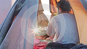 Handsome traveler in tent with coffee or tea cup