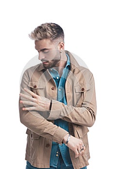 Handsome unshaved man in denim shirt making a hand gesture