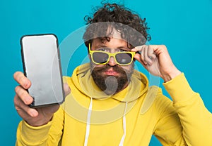 Handsome unshaved man with moustache showing telephone