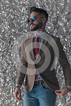 Handsome unshaved man with sunglasses looking to side