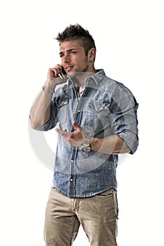 Handsome upset young man talking on cell phone (mobile)