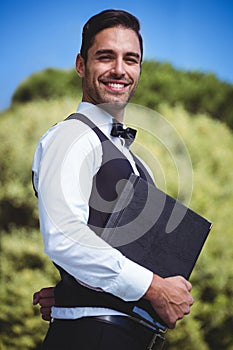 Handsome waiter holding menus