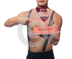 Handsome waiter points to a glass of red wine on a tray