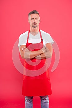 Handsome waiter in red apron. Successful small business owner. serious confident mature waiter entrepreneur. waiter in a