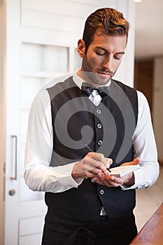 Handsome waiter taking an order