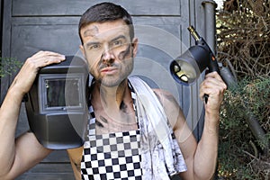 Handsome welder holding a blowtorch