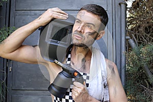 Handsome welder holding a blowtorch