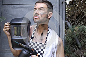 Handsome welder holding a blowtorch