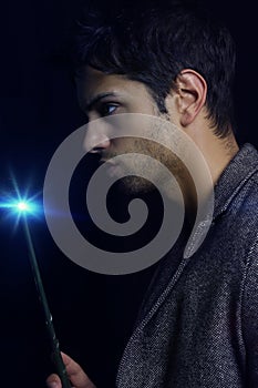 Handsome wizard man holding magic wand