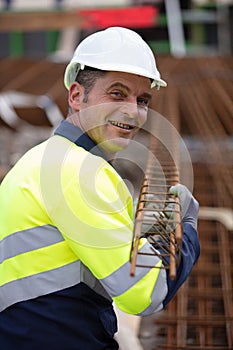 handsome worker carrying metal rod