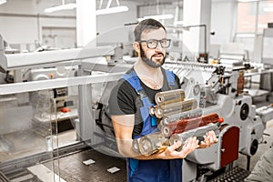 Worker with stamping foil rolls at the manufacturing